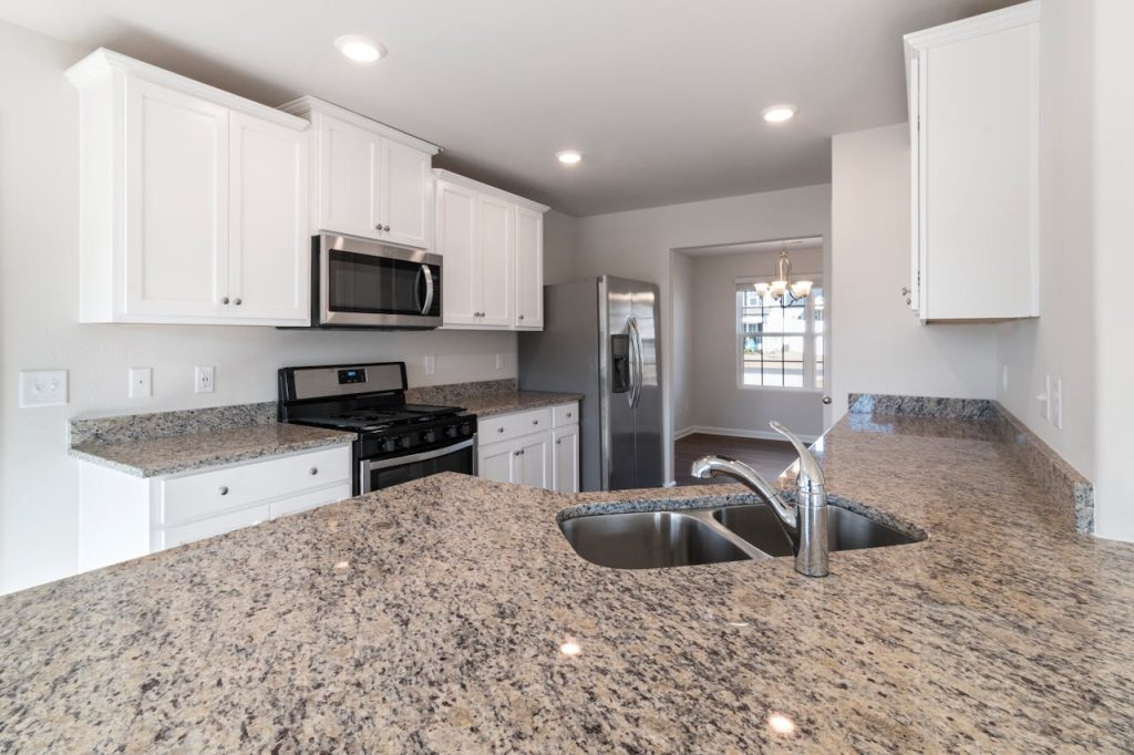 Sleek kitchen interior featuring granite countertops and stainless steel appliances